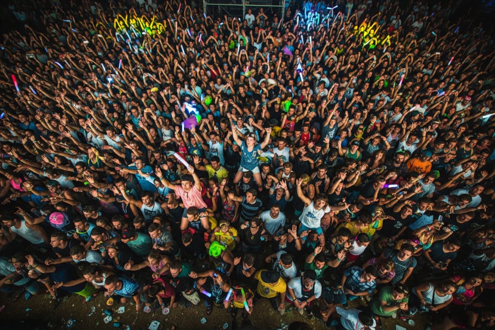 A large crowd of hardstyle fans dancing together at a major festival