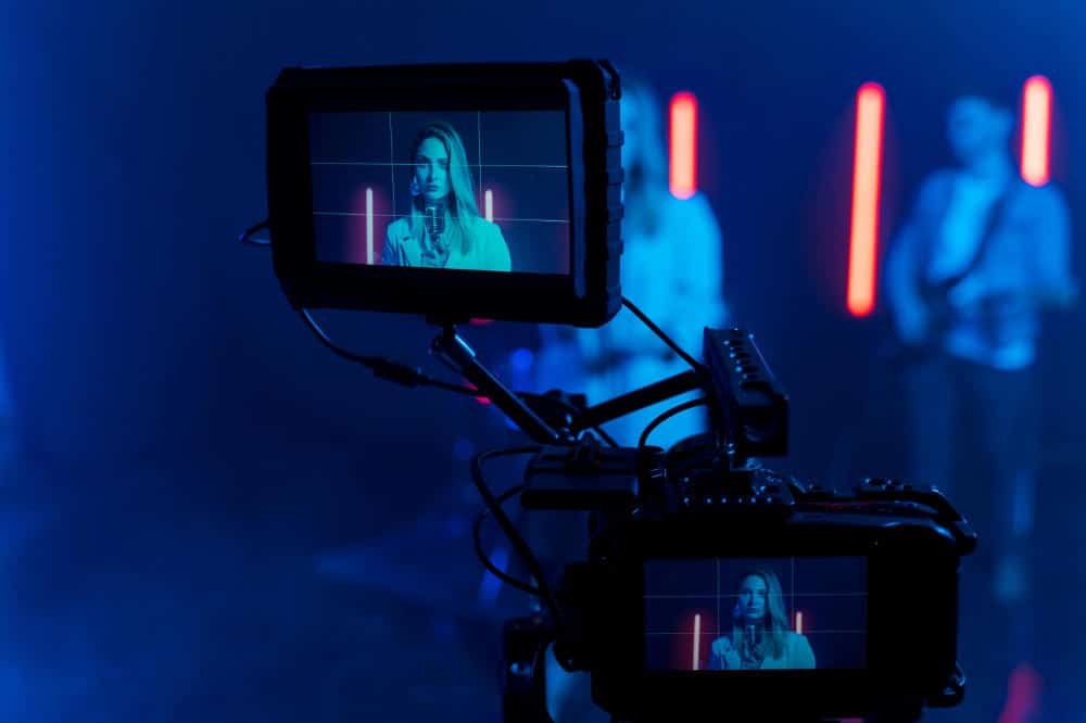 a singer is filmed with a reflex camera for a music video