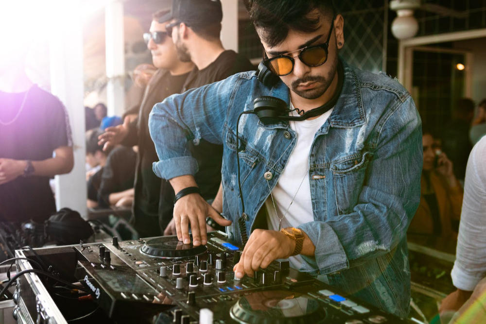 Male DJ playing music on Pioneer DJ Mixer