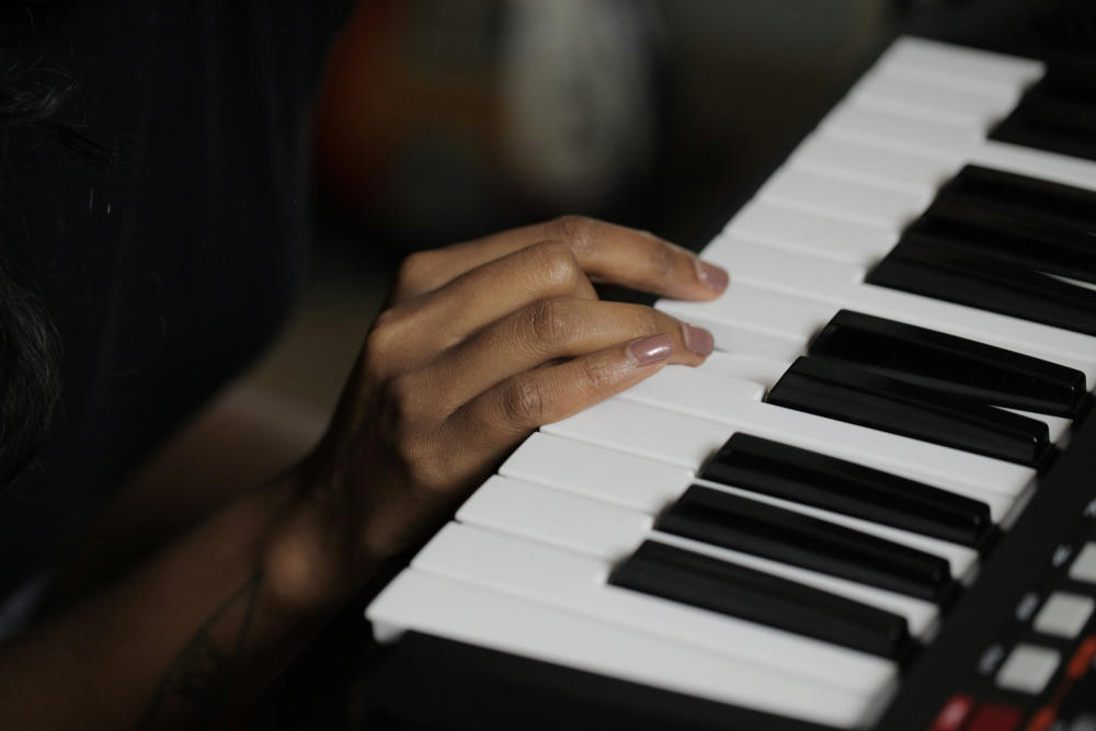 women hand plays on midi keyboard